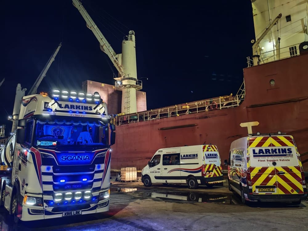 Larkins Scania tanker unit and two fleet support vans at a dockside at night